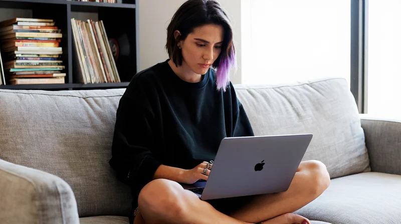 young woman setting up her altscene dating profile on a laptop